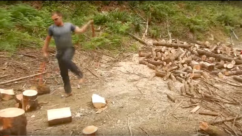Man Chops Wood With Two Axes