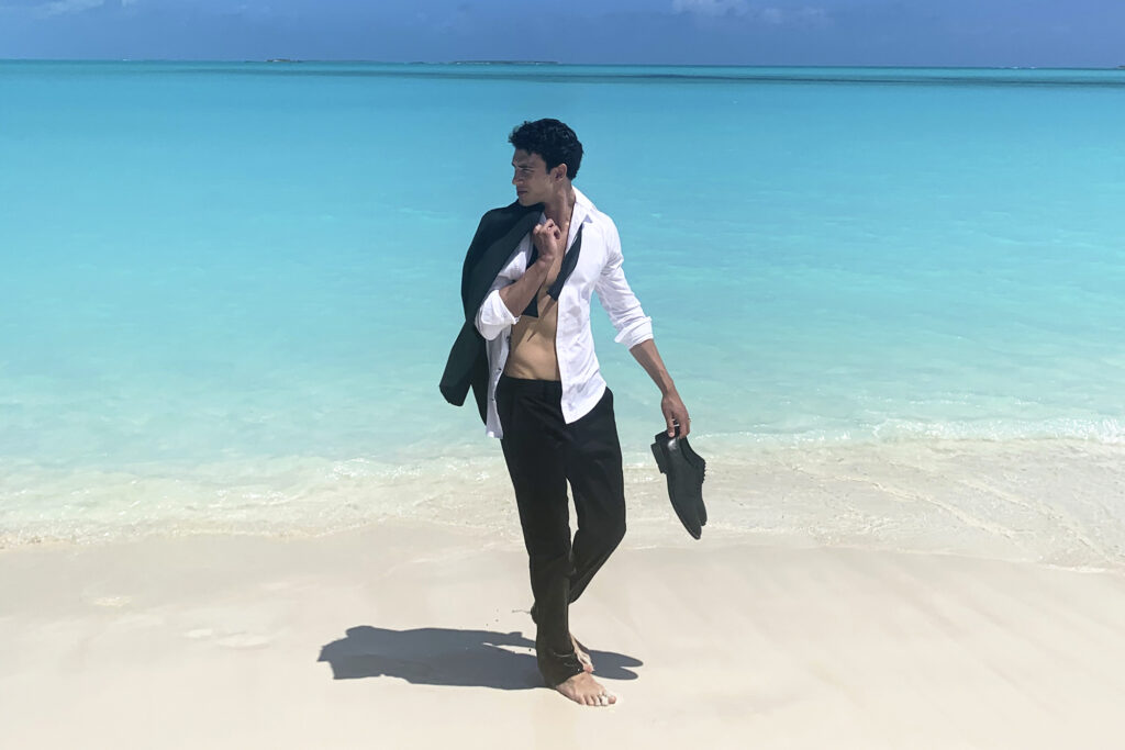 GUESS Uomo Acqua model standing on sandy beach