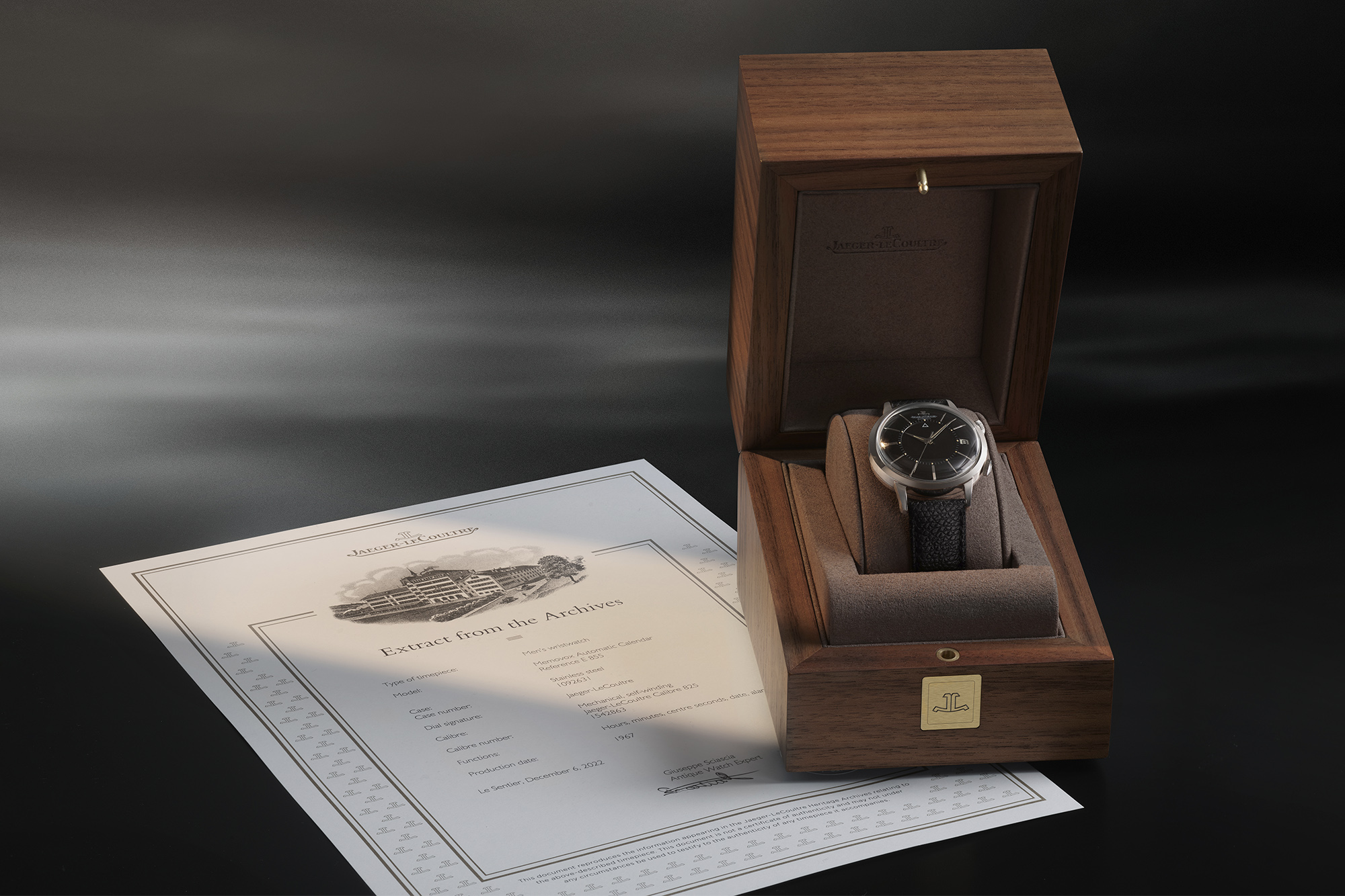 Jaeger-LeCoultre watch in wooden box with paper beneath it