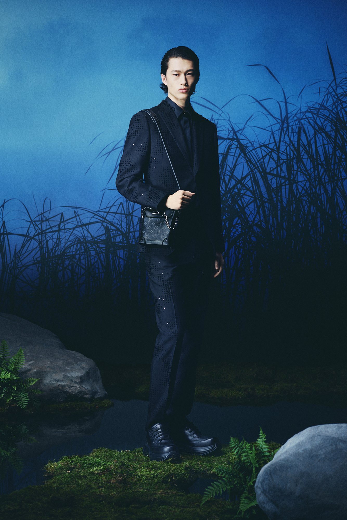 Louis Vuitton Men's Collection Pre Spring/Summer 2024 model in forest wearing dark suit