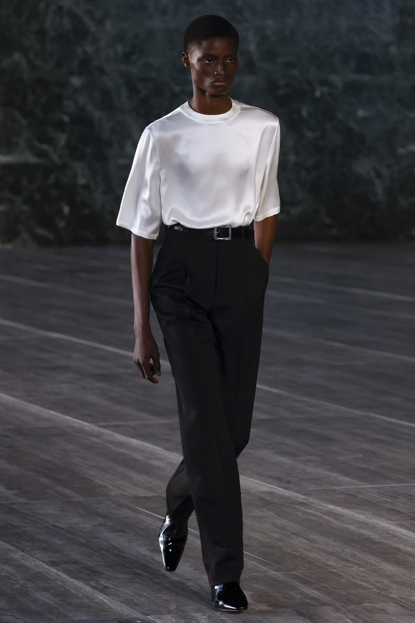 Saint Laurent Spring/Summer 2024 male model in satin t-shirt and dress pants on runway