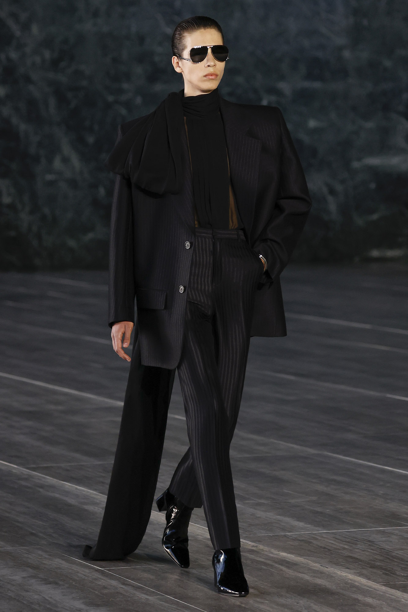 Saint Laurent Spring/Summer 2024 male model in all-black suit draping to the floor on runway
