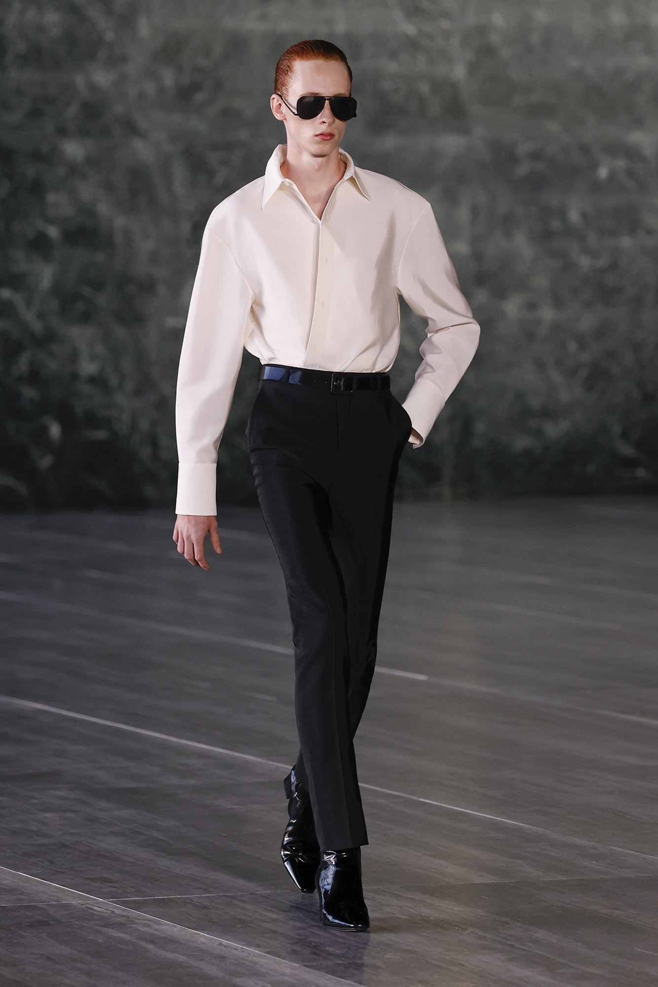 Saint Laurent Spring/Summer 2024 male model in white shirt black pants and sunglasses on runway