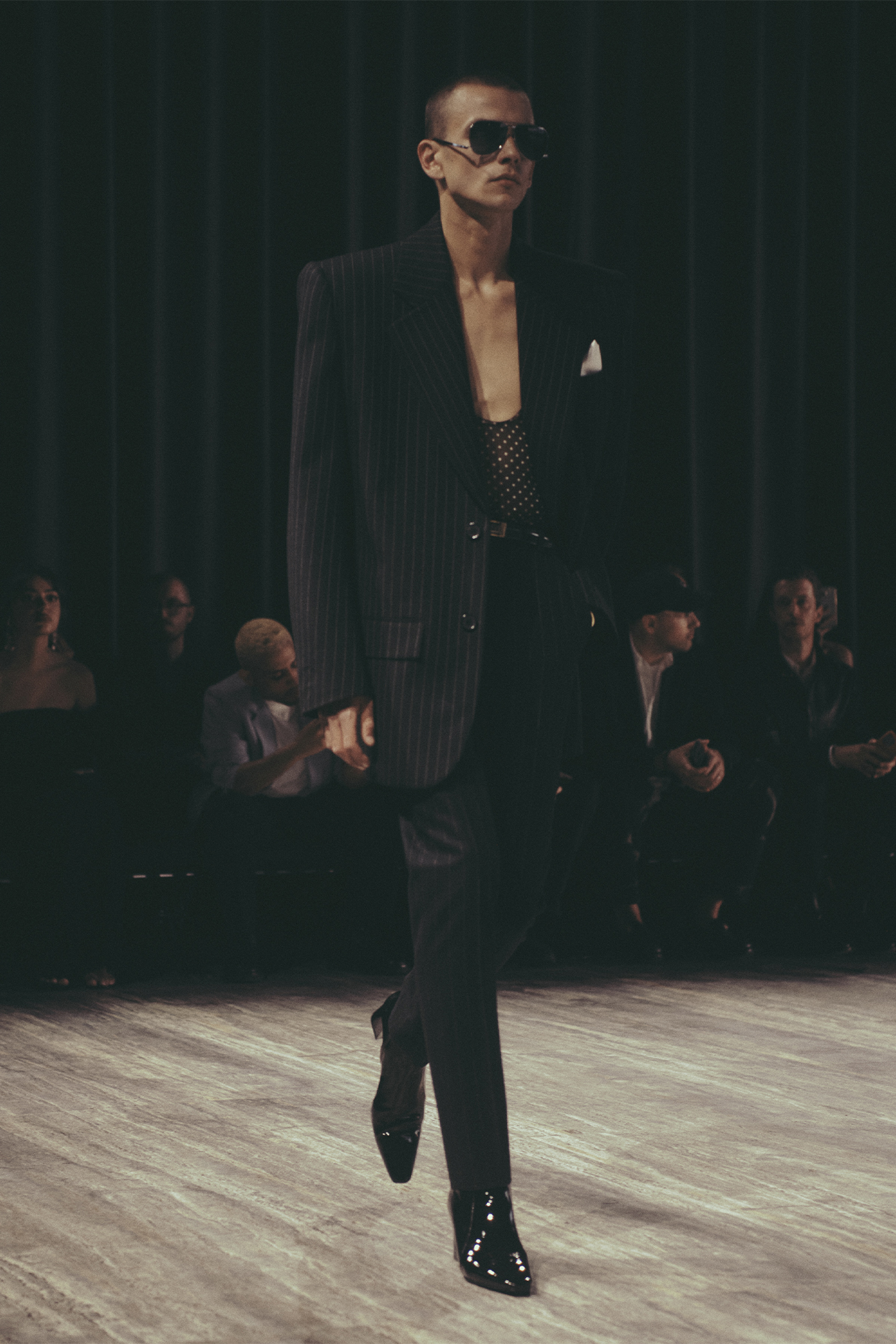 Saint Laurent Spring/Summer 2024 menswear model waling in suit with sunglasses