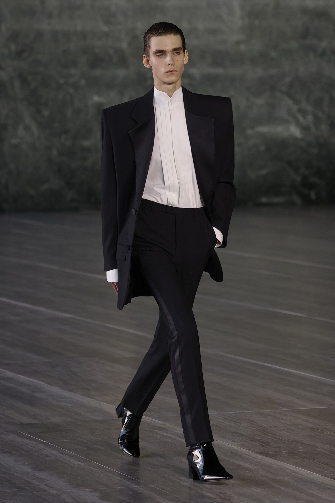 Saint Laurent Spring/Summer 2024 male model in suit with exaggerated shoulders and white button down on runway