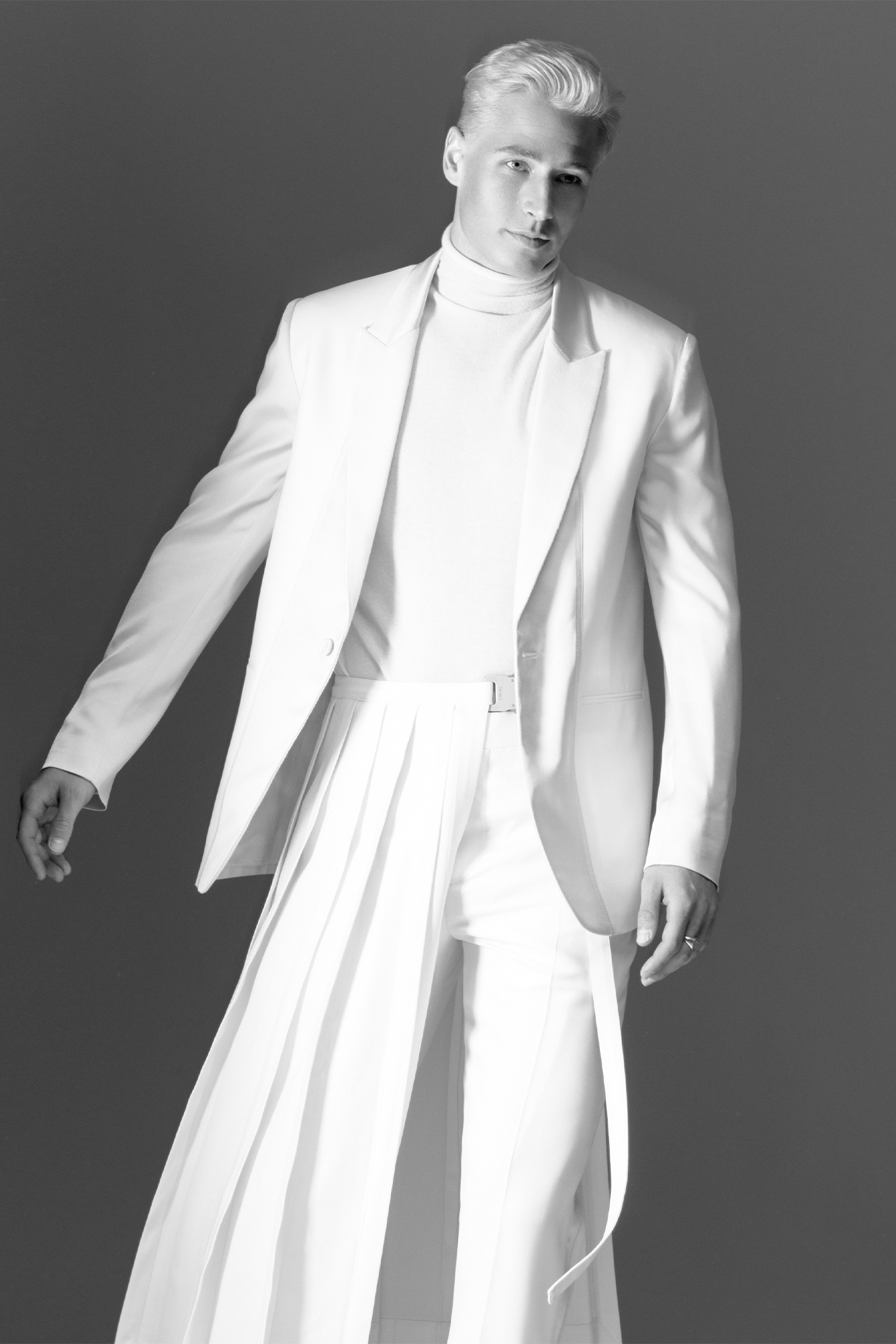 Male model in black and whiten white suit jacket and flowy bottoms