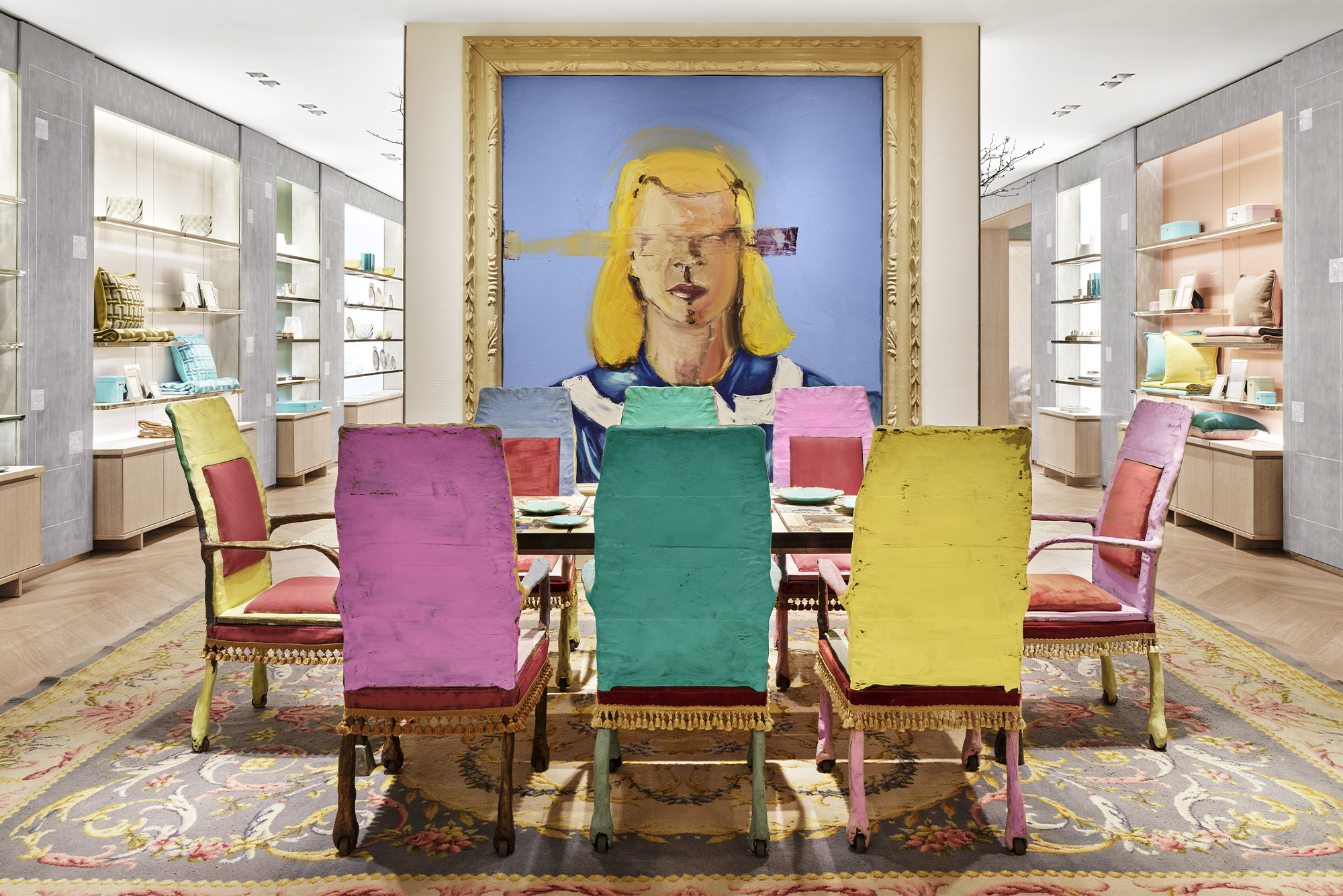 Tiffany & Co. The Landmark interior pink, teal, and yellow chairs in front of a painting