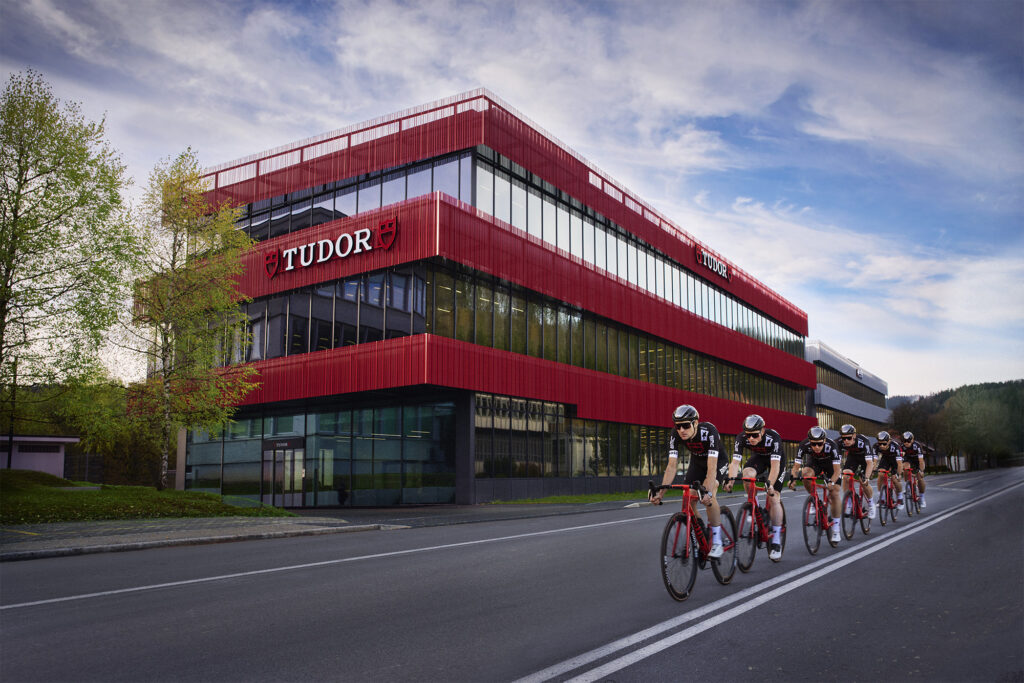 Tudor Pro Cycling cycles past building 