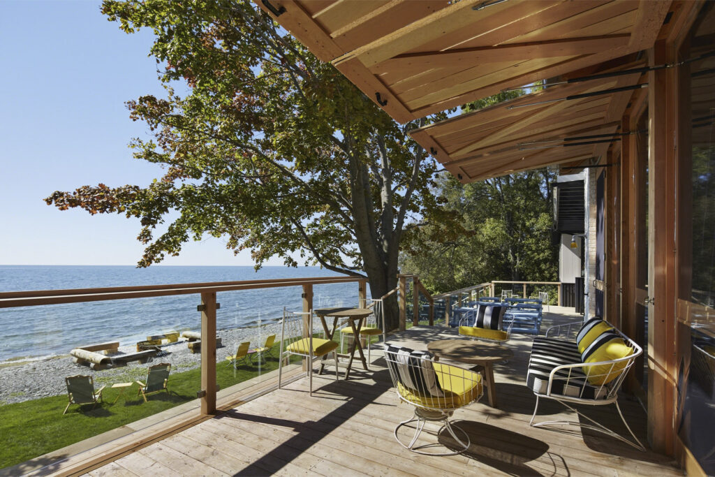 Drake Devonshire patio during sunny day with wooden guard rail and lake view