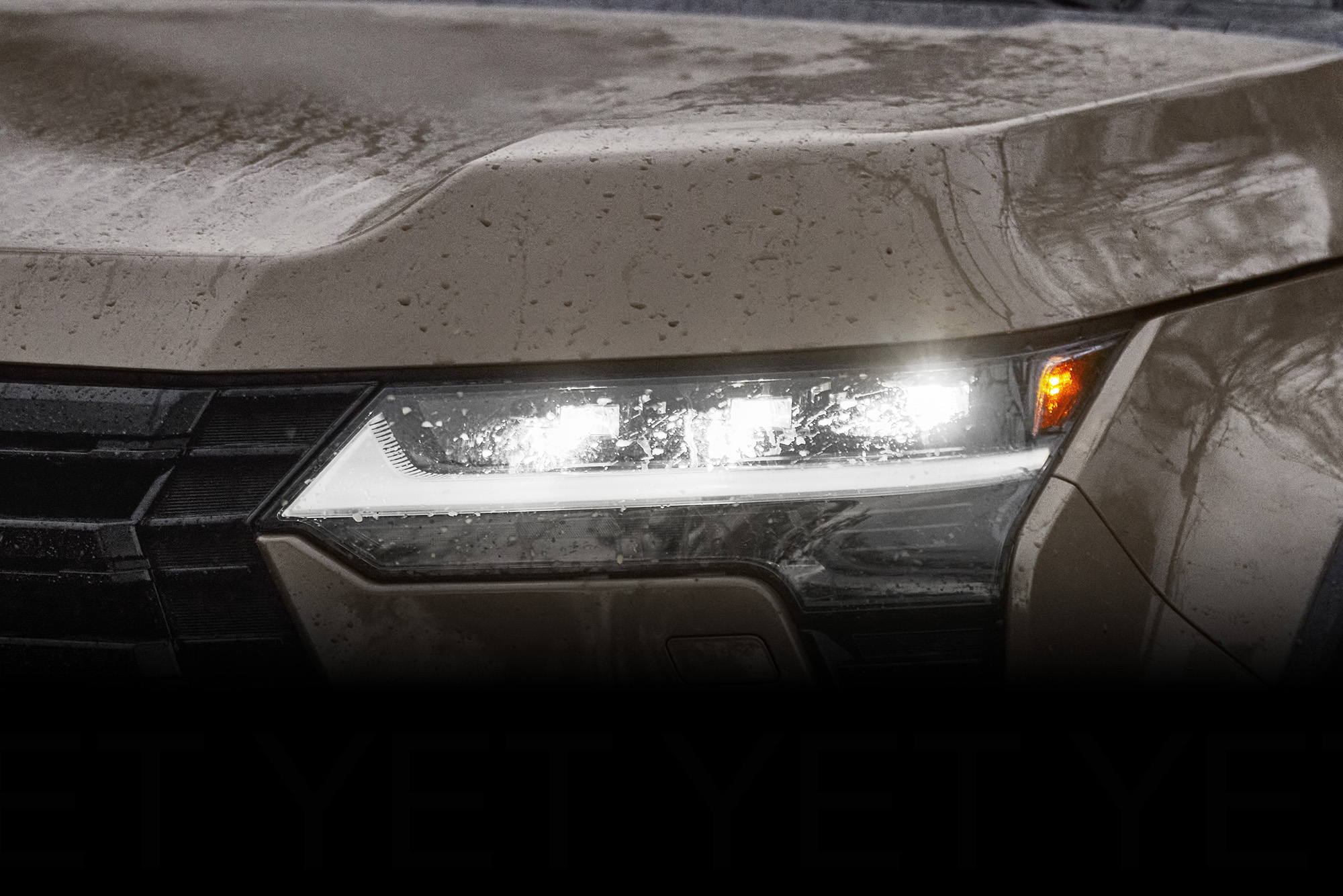 Lexus GX tan suv close up of lit headlight