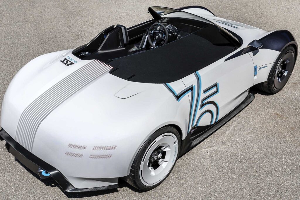 Porsche Vision 357 Speedster shot from bird's eye view. shows the rear-side angle of a white and blue convertible with 75 painted on the side
