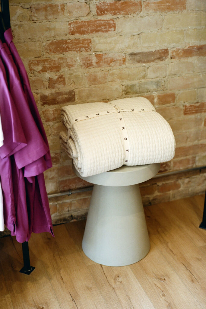KOTN store close up on sweater wrapped atop stool