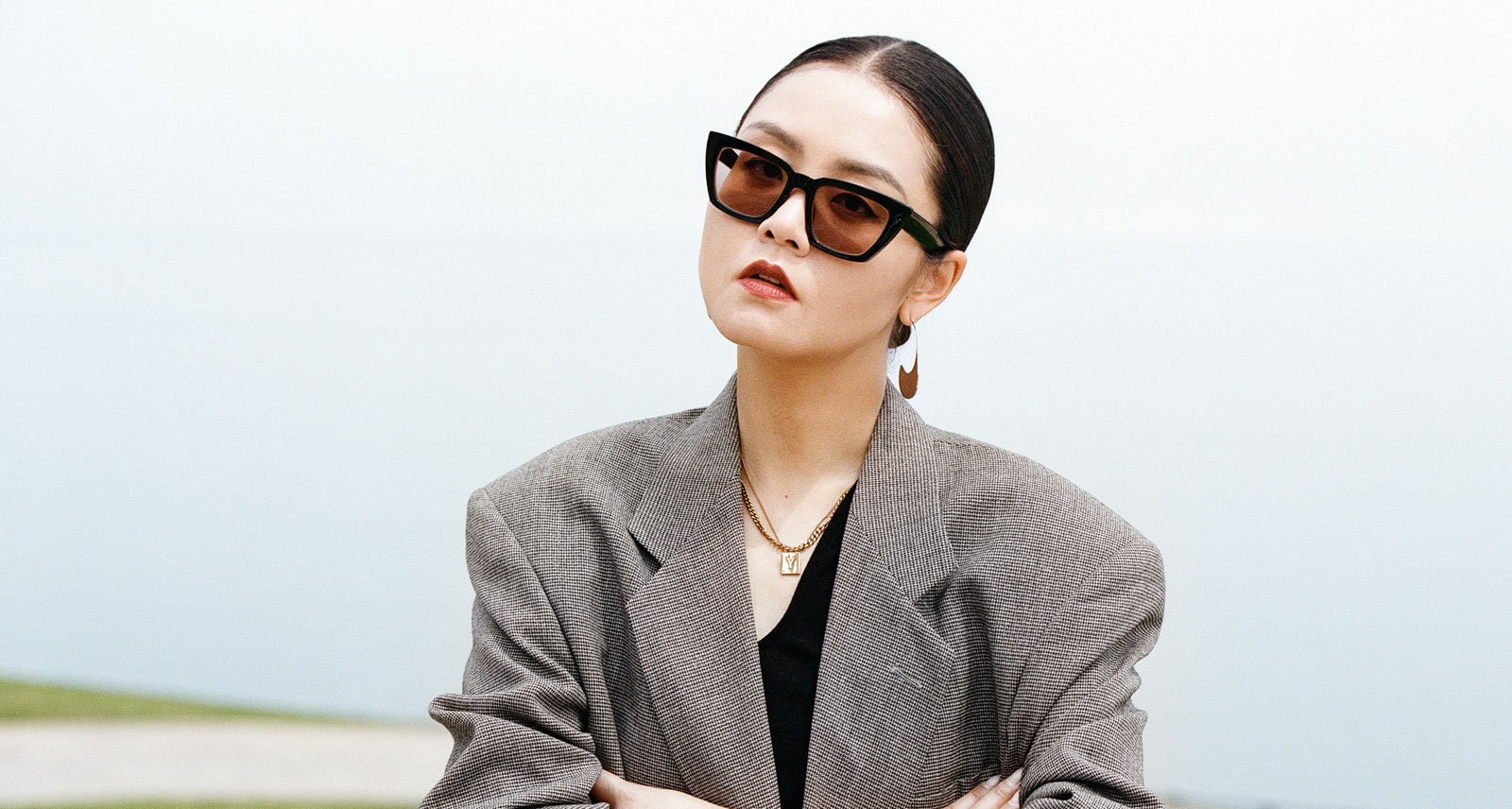 Yuki Zhao interview Range Rover content head shot grey jacket and shades hair in slicked ponytail