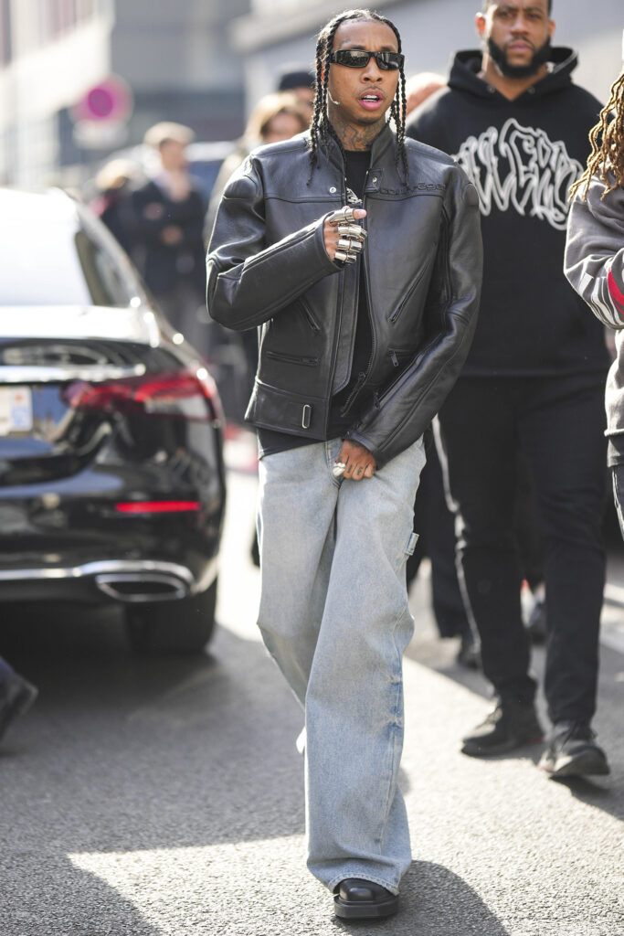 Tyga celebrity streetwear sunglasses leather jacket  and light wash pants
