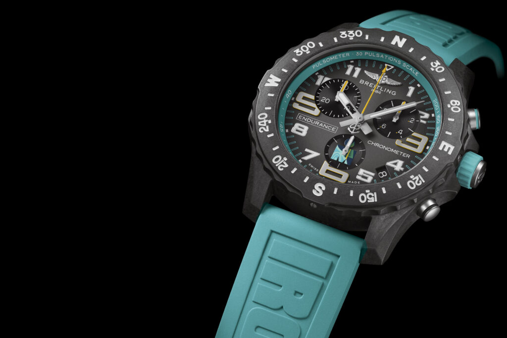 Limited Edition Breitling Endurance Pro for Ironman in turquoise on black background, the watch is on the right side of the frame with the dial showing and band leading off the edge