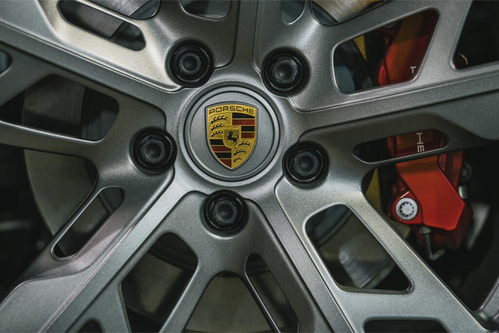closeup of silver hubcap with porsche emblem 