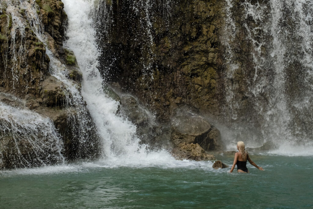 Woman swims in a waterfall at Sanubari Sunda, Indonesia