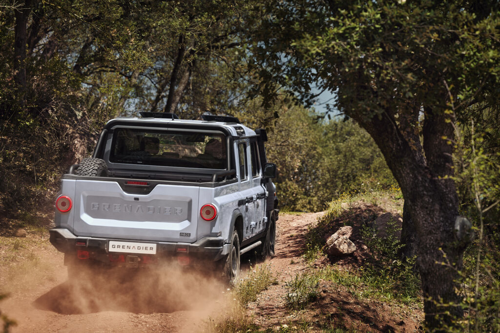 Ineos Grenadier Quartermaster drives up a dirt road, shot from the back