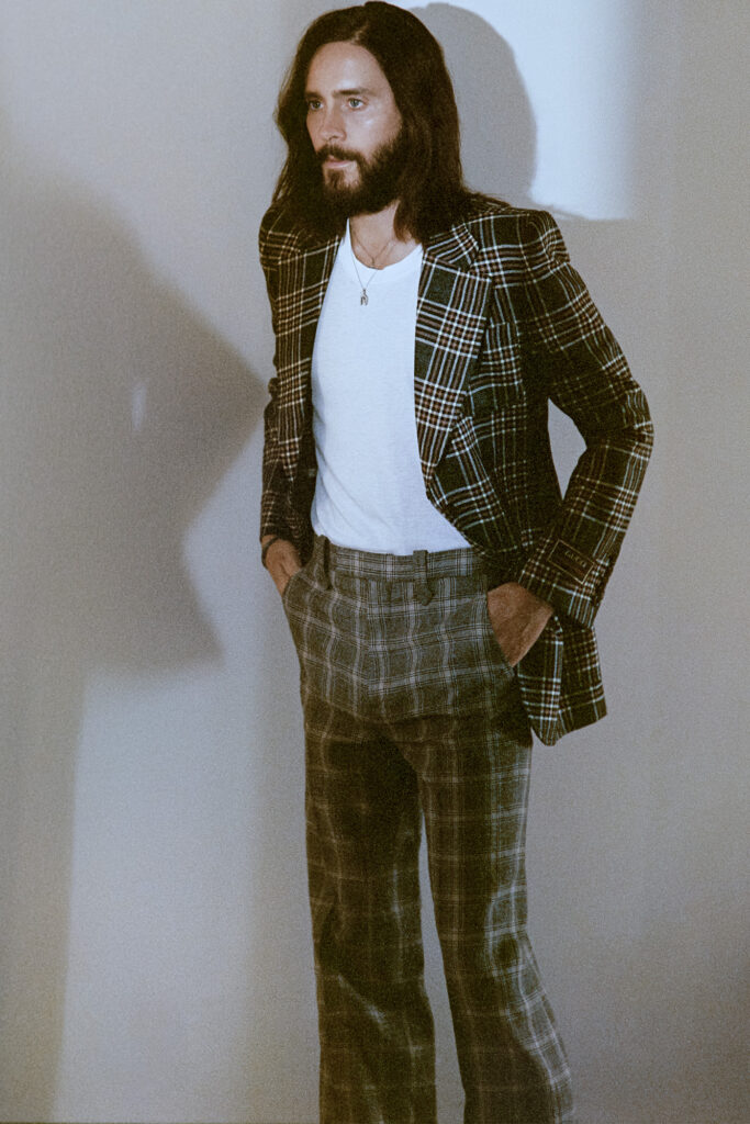 Jared Leto by white wall in plaid suit and white undershirt for SHARP September