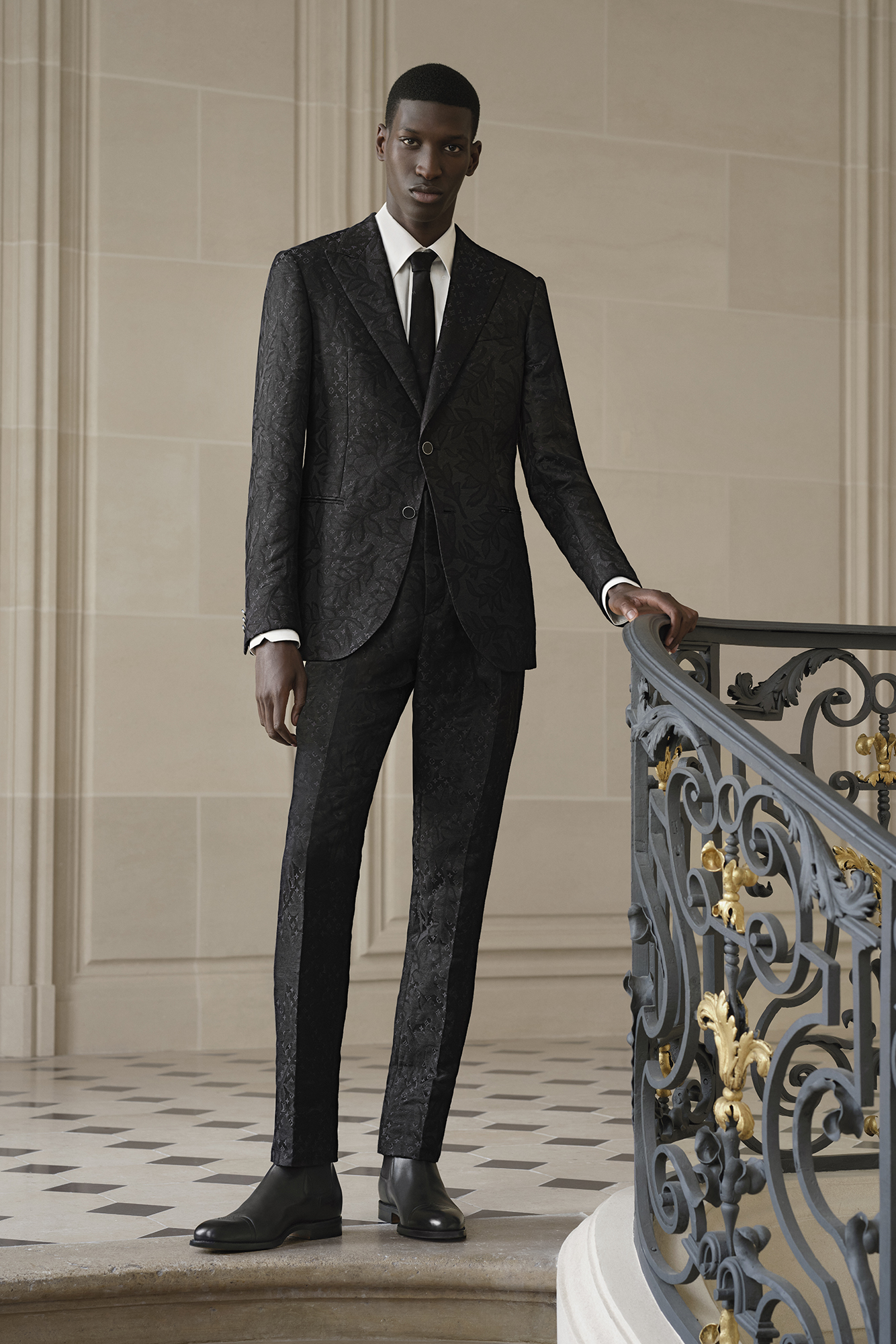 Model wearing a Louis Vuitton black suit poses