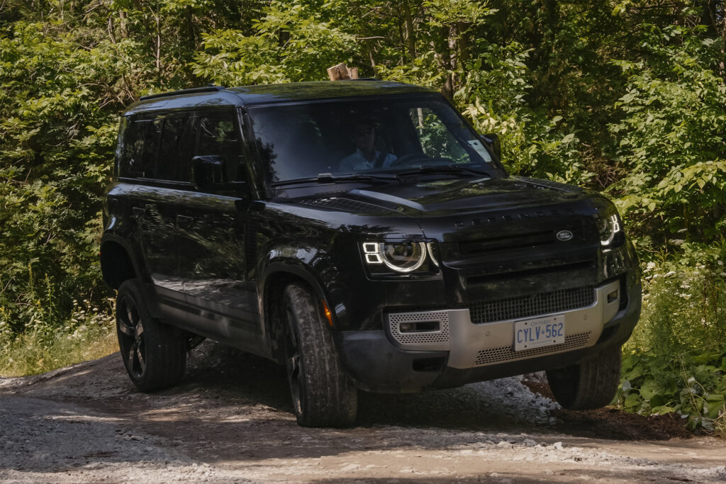 Black Land Rover Defender drives off-road