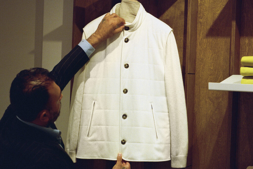 Man hanging a white jacket at Atelier Munro 