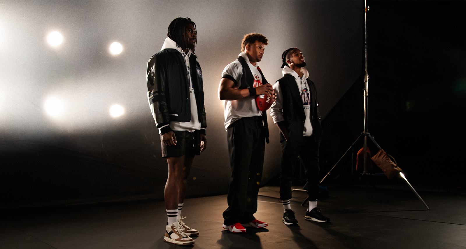 Three men stand on a stage modelling BOSS NFL collection