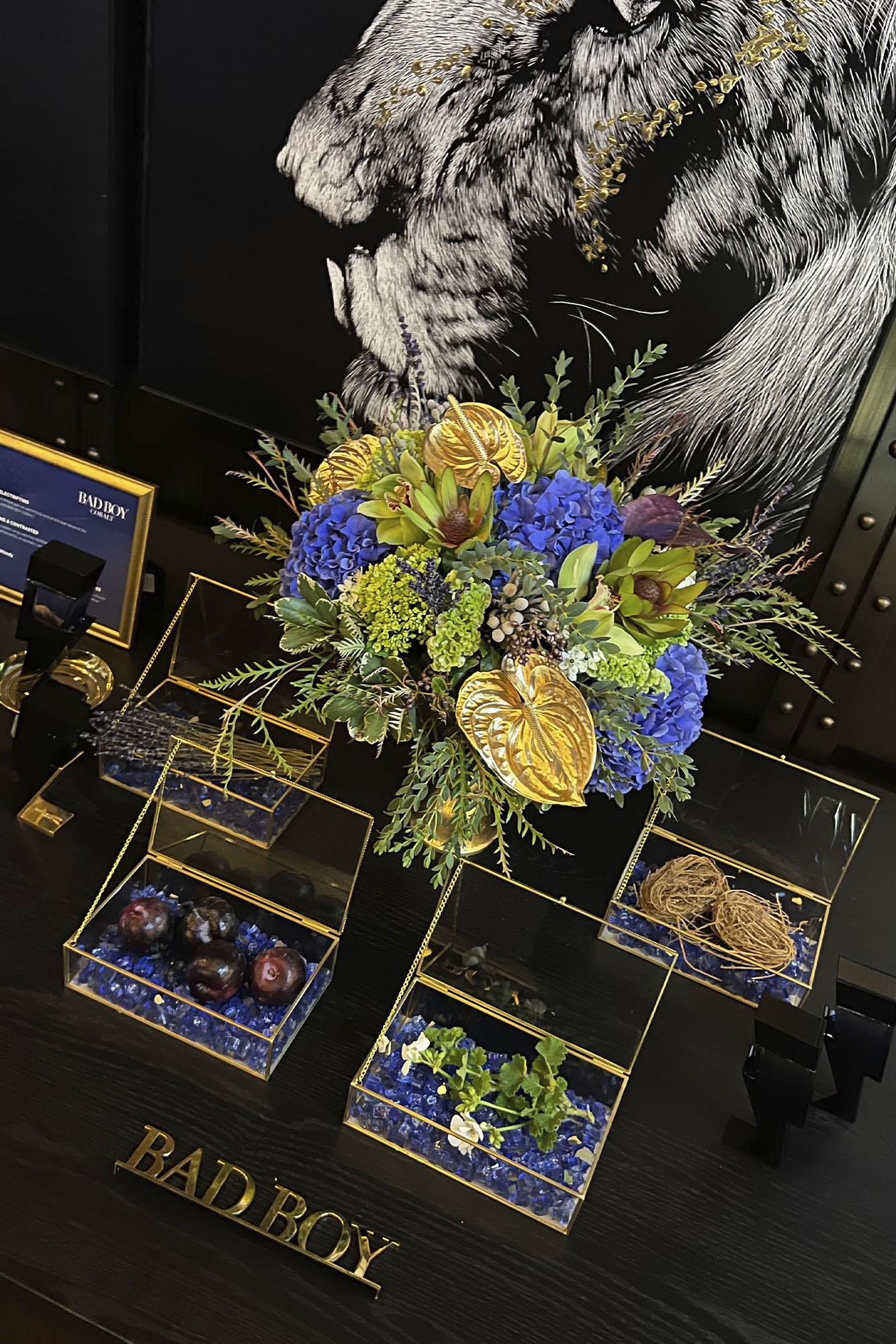 Bad Boy Cobalt launch party: table shows glass boxes with blue stones and flowers on black tablecloth