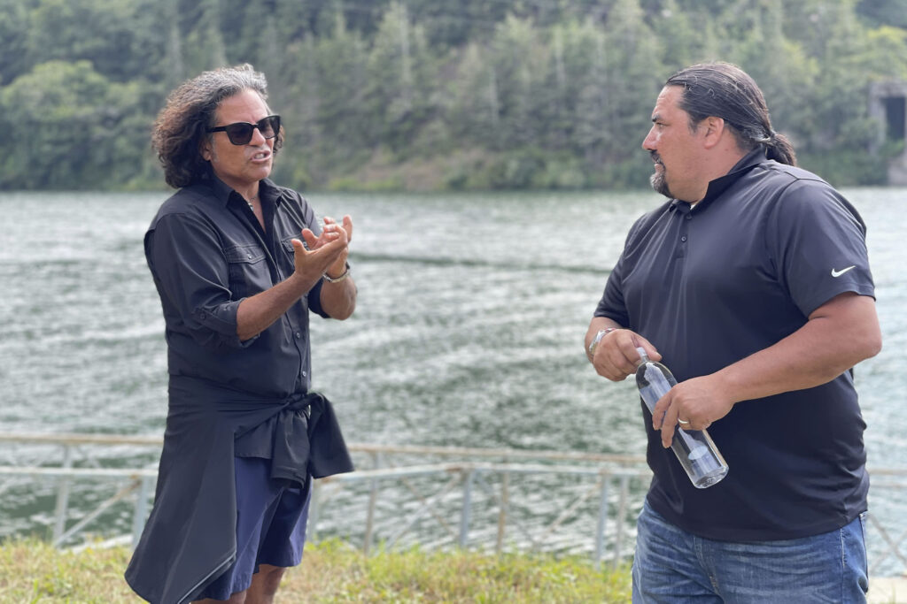 Two older men talk in front of a lake in film still from Boil Alert premiere