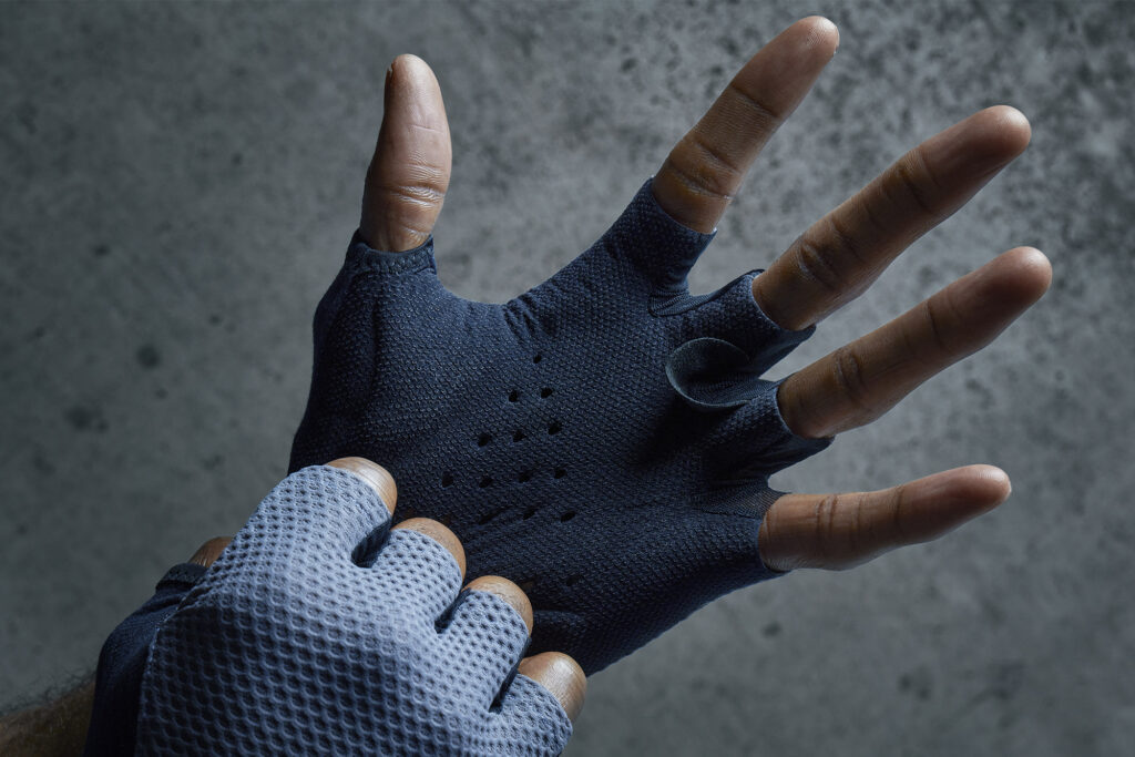 Hand putting on knitted fingerless blue gloves