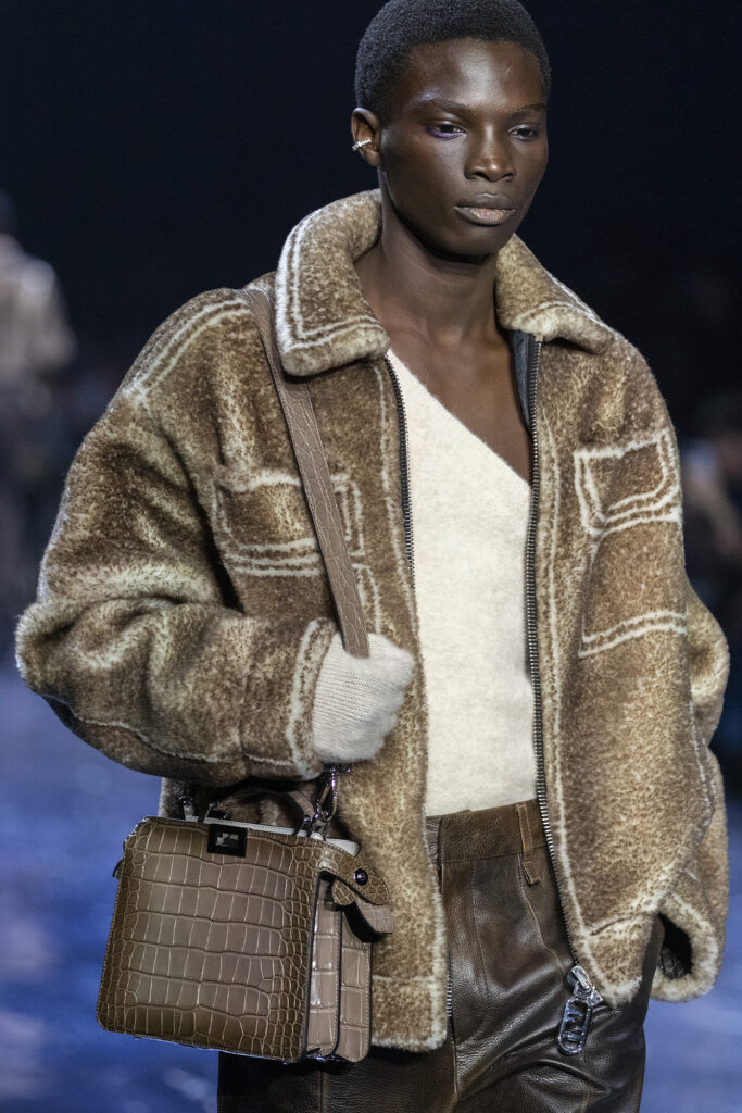 Model wearing a fur coat, white top, and brown fendi bag