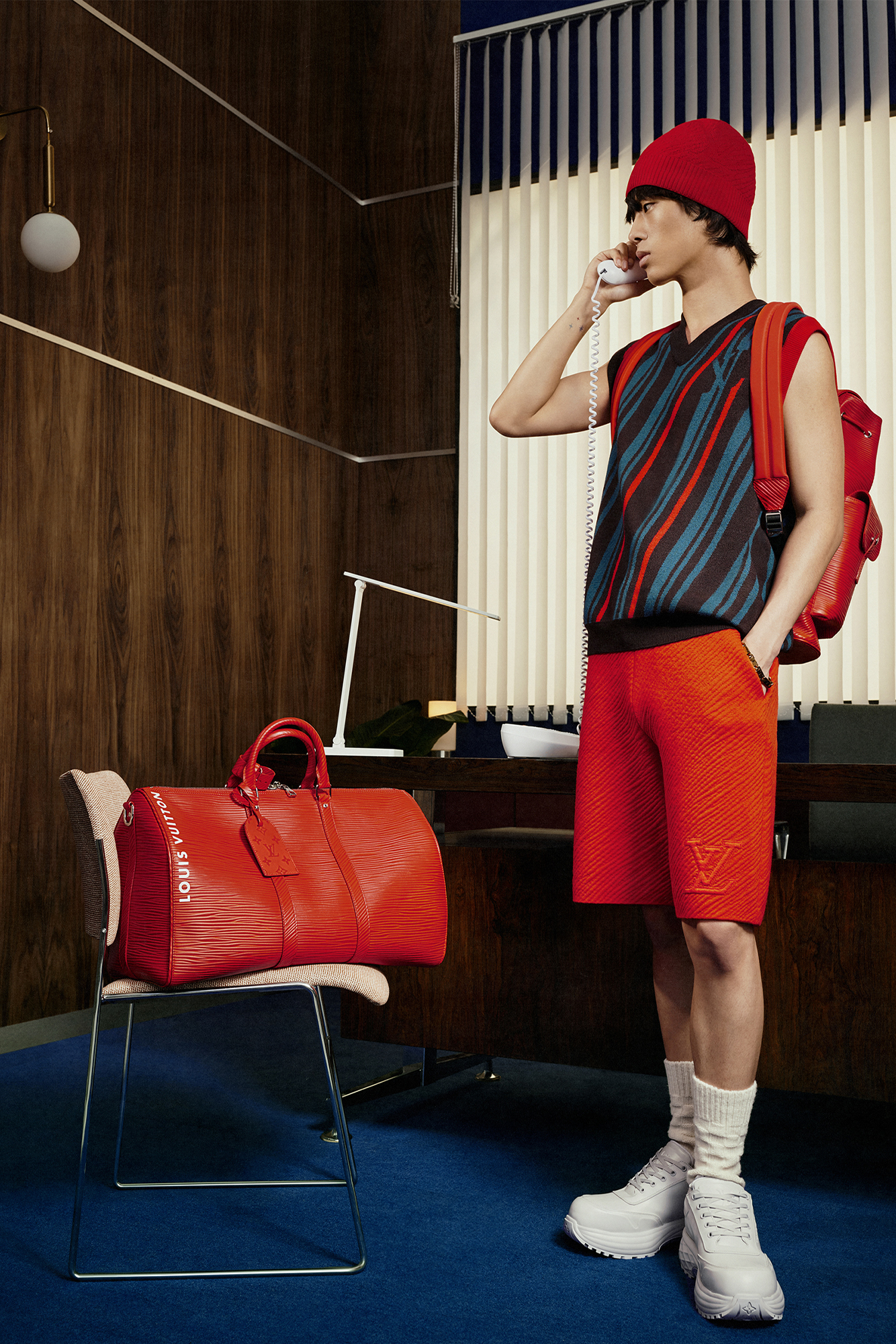 Model for Louis Vuitton Studio Prêt-à-Porter Homme with red shorts, vest, and red hat