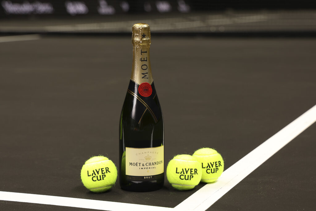 Moët & Chandon bottle on tennis court with three balls