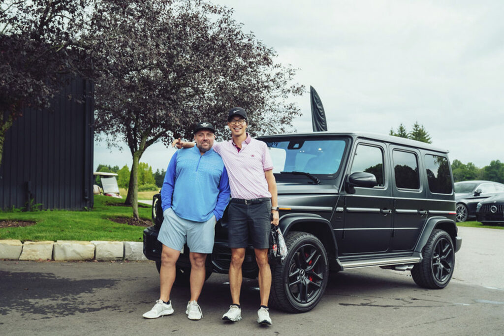 two geusts pose with car at Sharp x Mercedes-AMG Redtail Golf Club event