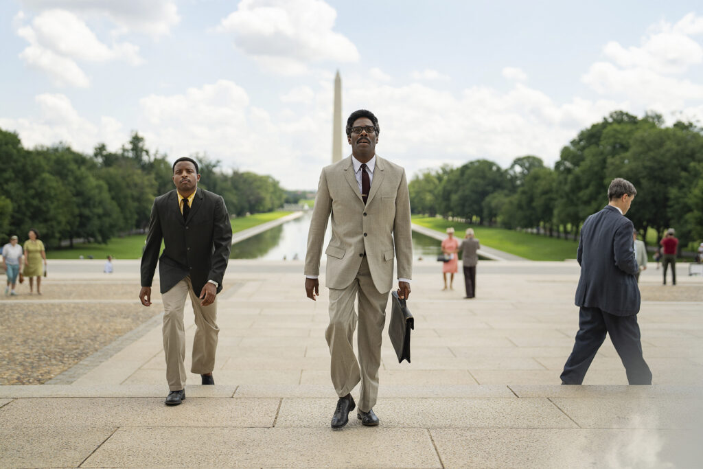 Film still from Rustin ahead of TIFF 2023 shows man in tan suit walking in front of Washington Monument