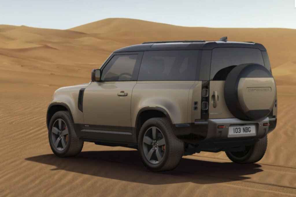 SHARP built Land Rover Defender shot from the back left corner while parked in a desert