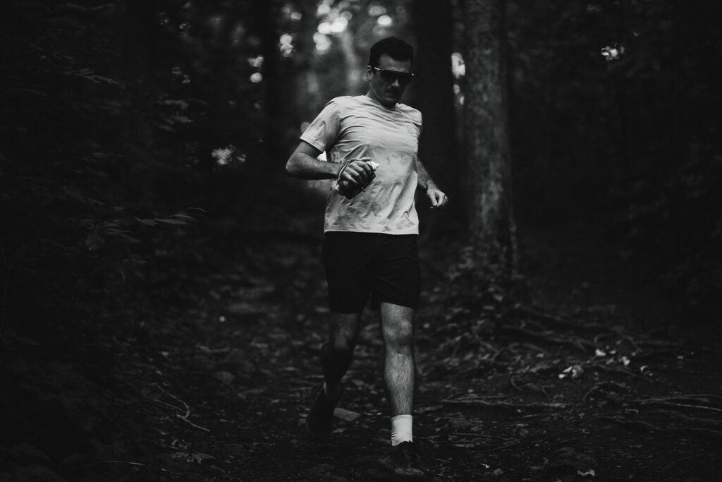 Ostrya founder François-Xavier Tétreault jogging through the woods in black and white photo