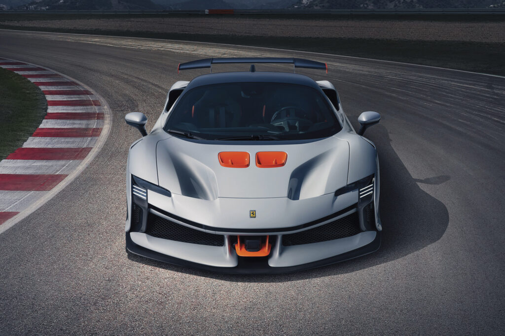Ferrari SF90 XX driving on a racetrack shot from the front