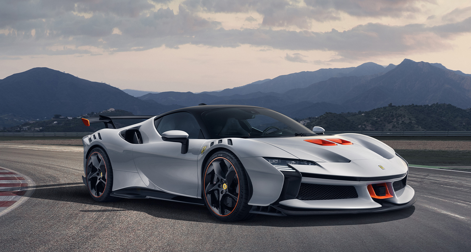 White Ferrari SF90 XX car on a racetrack with mountains in the background
