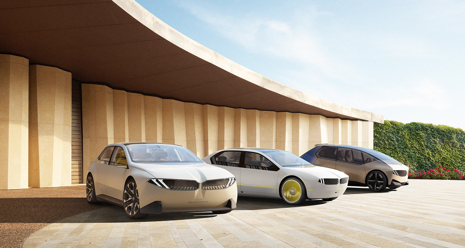 Three BMW cars parked outside a futuristic garage BMW Vision Neue Klasse