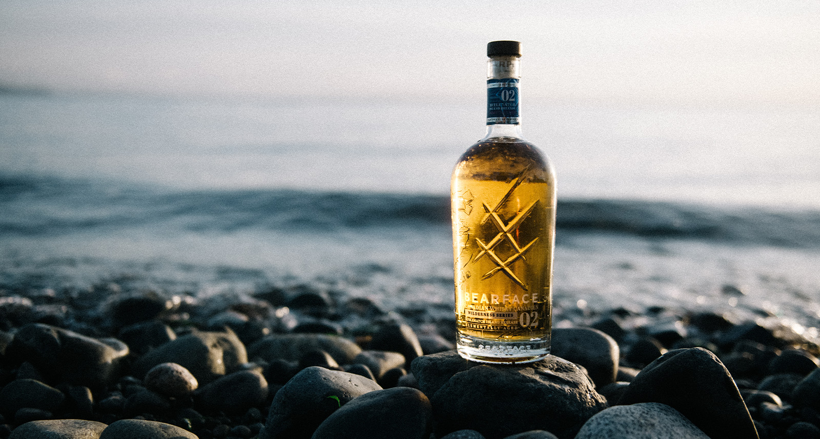 bearface whisky on a rocky shore by the ocean