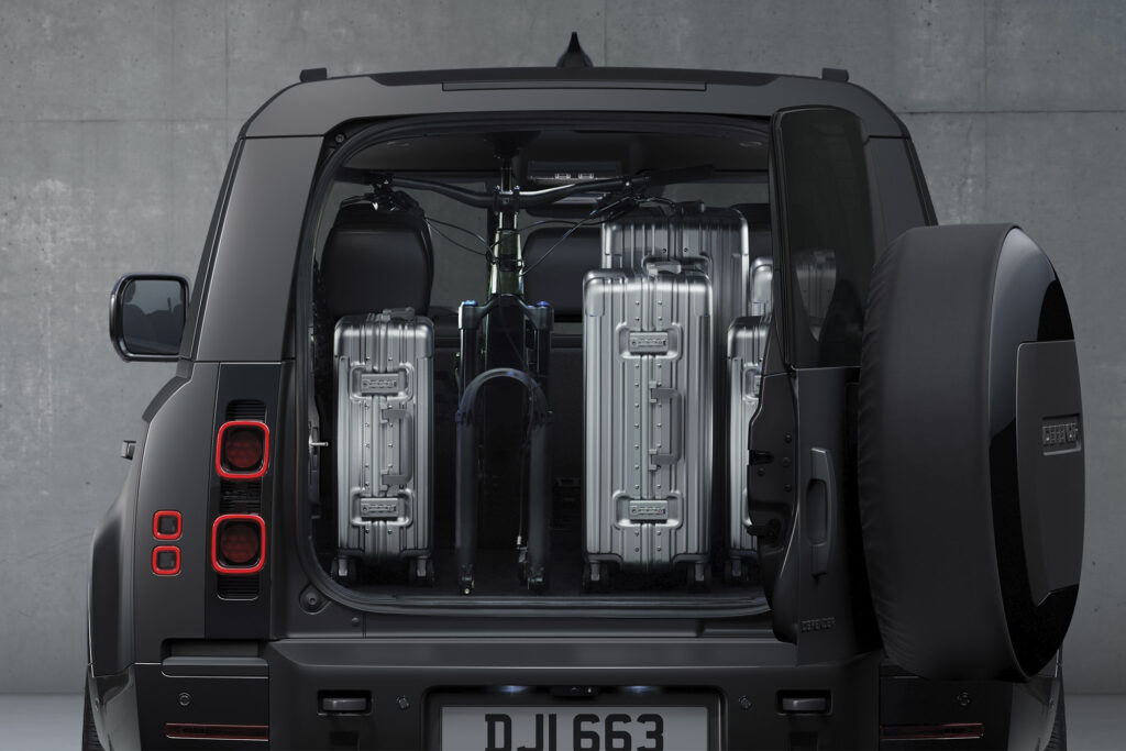 Land Rover Defender parked with two suitcases in the back