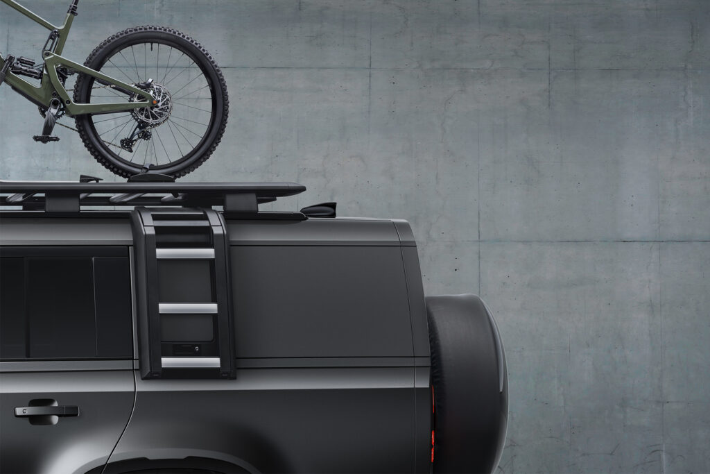 Land Rover Defender with bike on its roof, back half from side