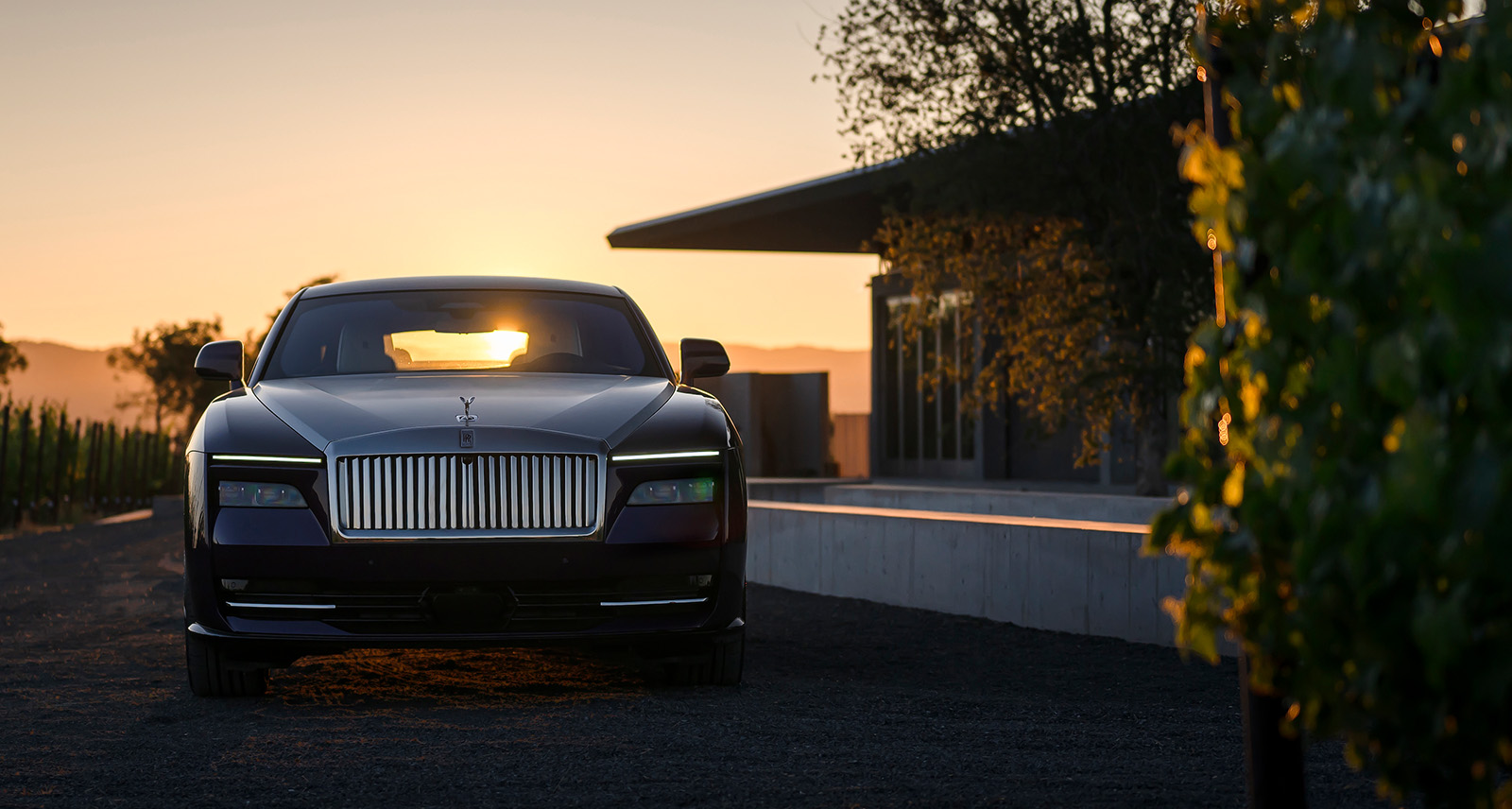 Rolls-Royce Spectre parked outside a house during sunset