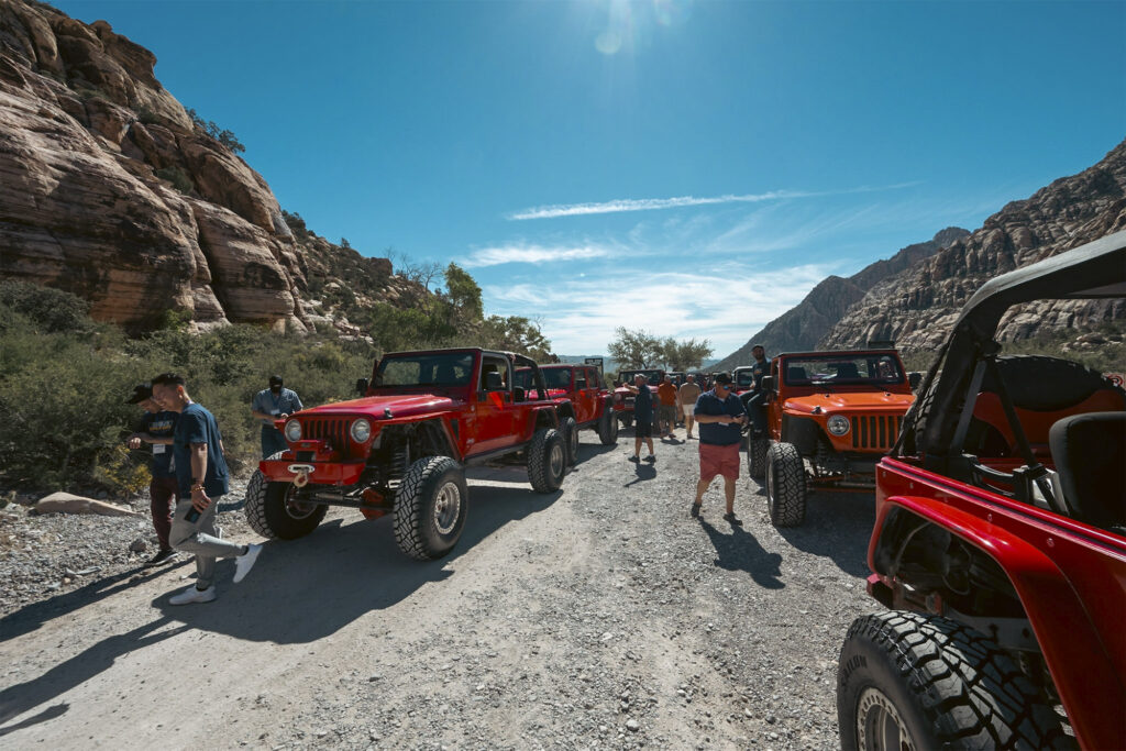a bunch of red jeep wrangles parked in the desert