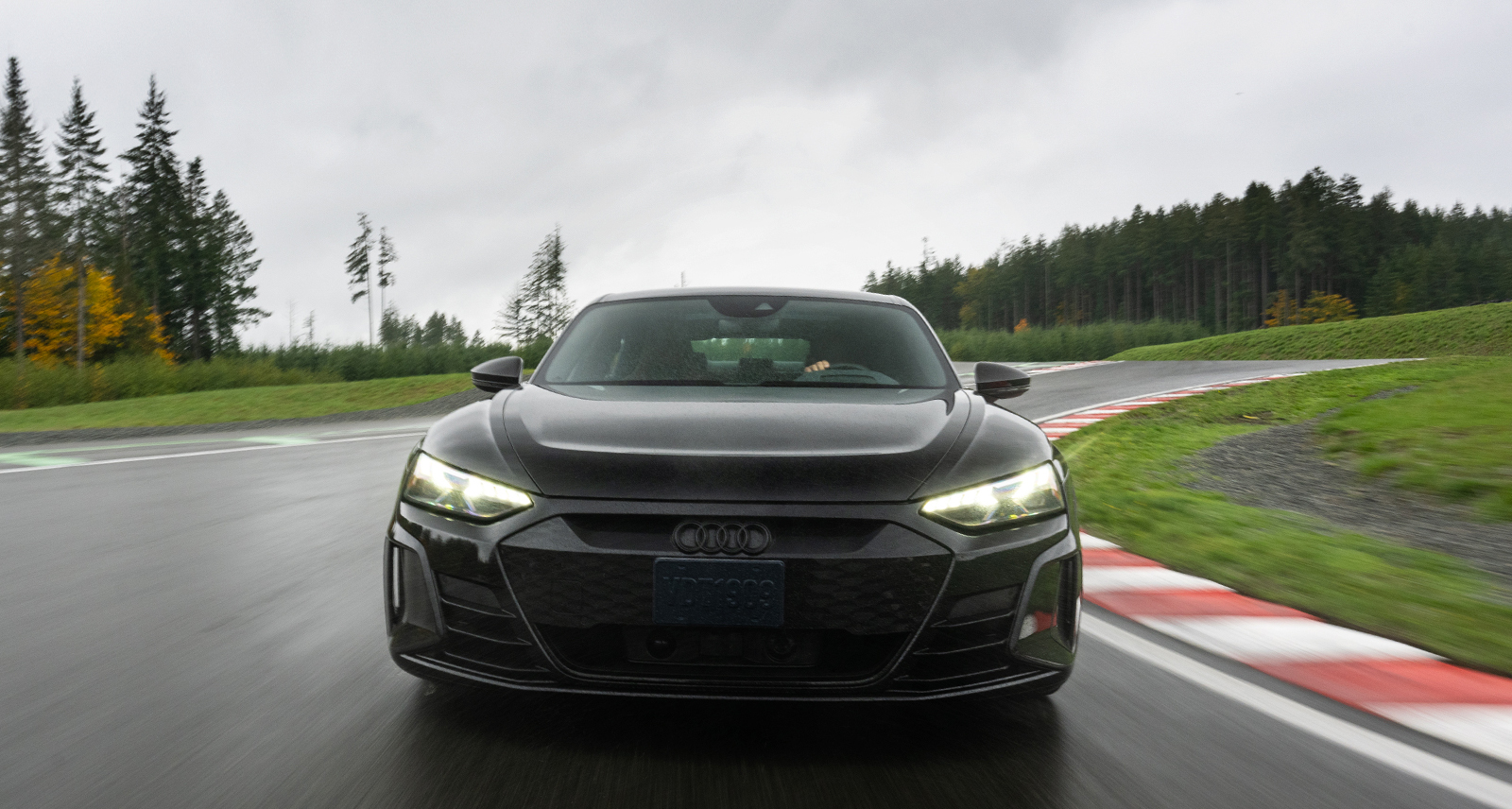 Audi drives on racetrack, close-up shot of headlights
