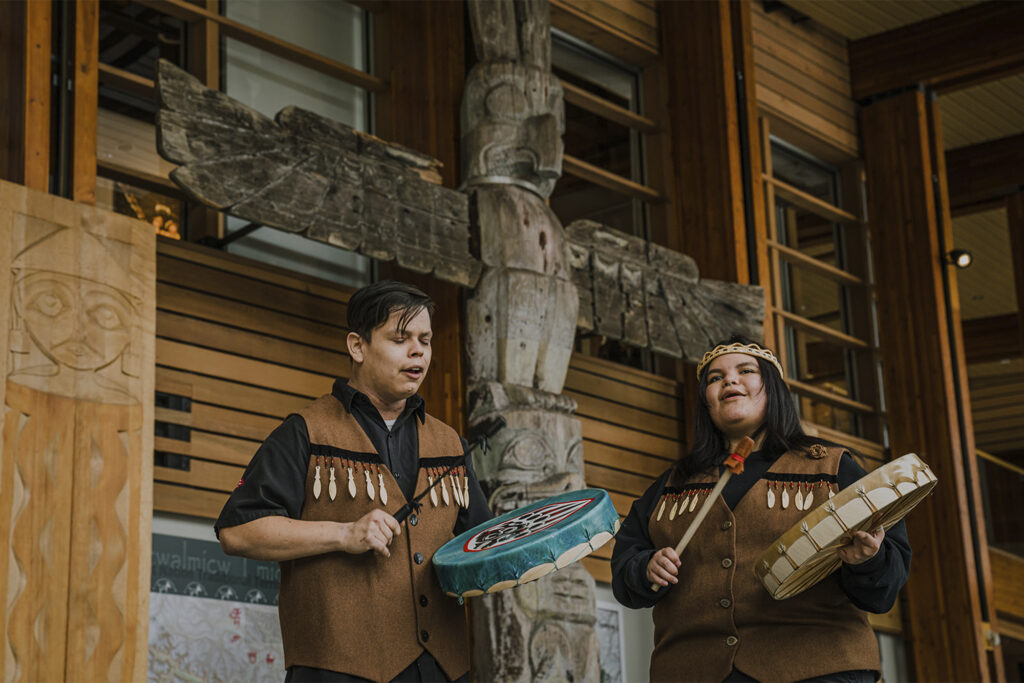two people play the drums at Squamish Lil’wat Cultural Centre