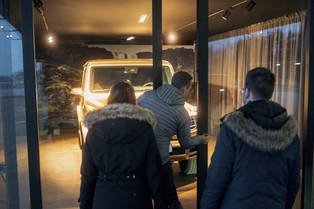 two people look at a Mercedes G-Class in a showroom