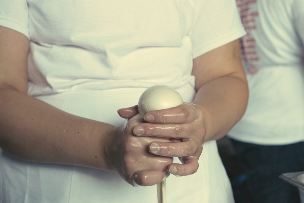 two hands make an egg shape with pasta dough