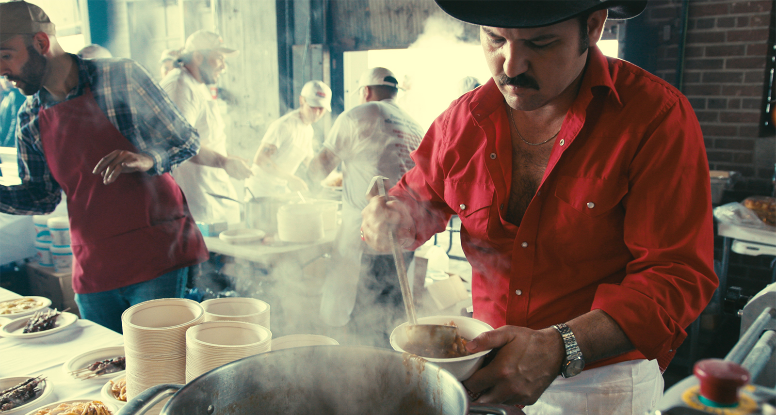 Sagra di Toronto Food Festival. A chef mixes a pot while another, larger pot steams in the foreground.